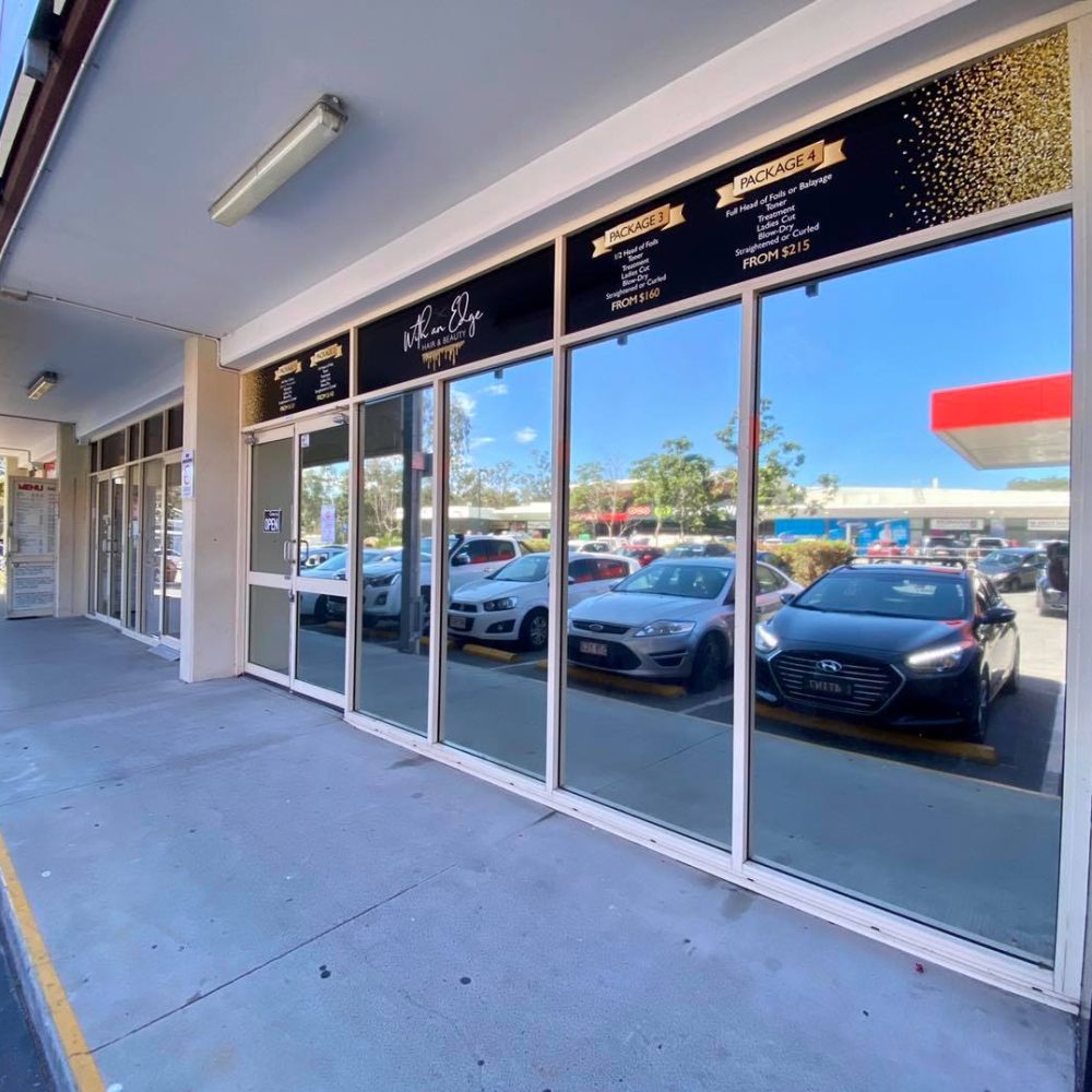 Tint a Home technician installing anti-graffiti window film on Gold Coast commercial property storefront